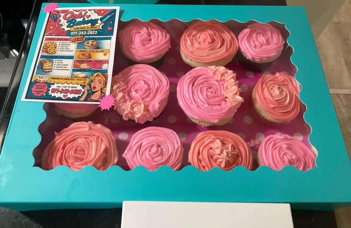 A dozen cupcakes with pink rosette frosting